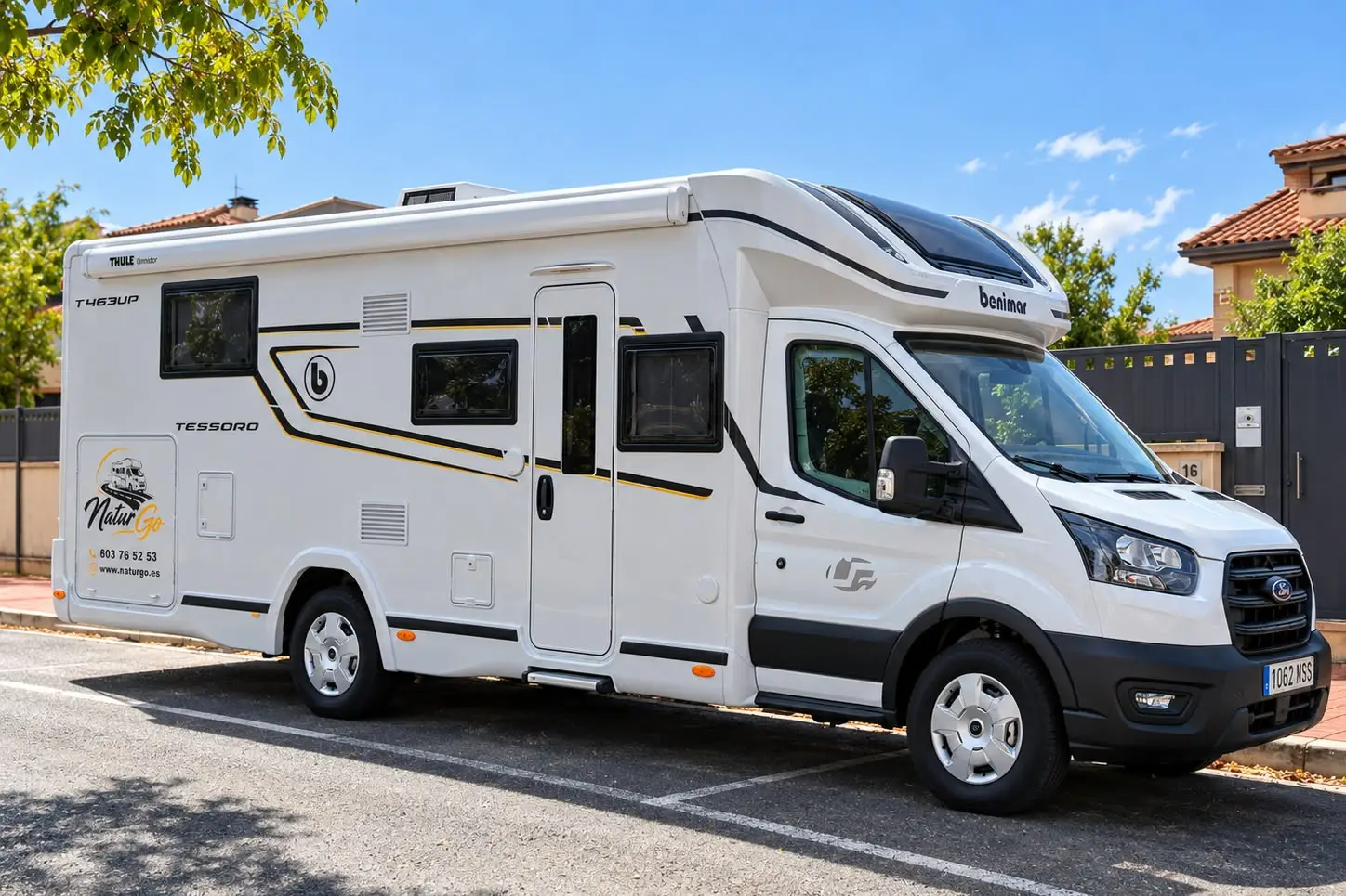 La autocaravana NaturGo aparcada de día, vista lateral y frontal con el rótulo de NaturGo